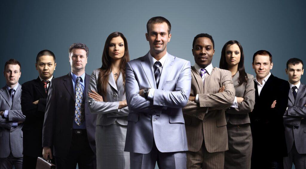 Diverse group of business professionals standing confidently in formal attire.