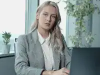 Professional woman working at a desk with a laptop, symbolizing IT certification success.