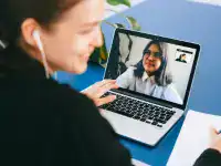 Person participating in an online IT certification training session via laptop.
