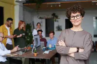 Leading woman in a modern office with diverse team working on laptops and tablets.