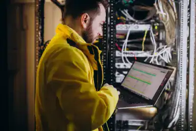 Network technician troubleshooting server hardware in data center.