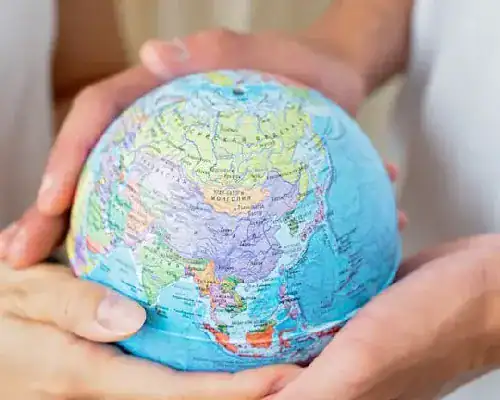 Hands holding a small globe representing global IT certification opportunities.