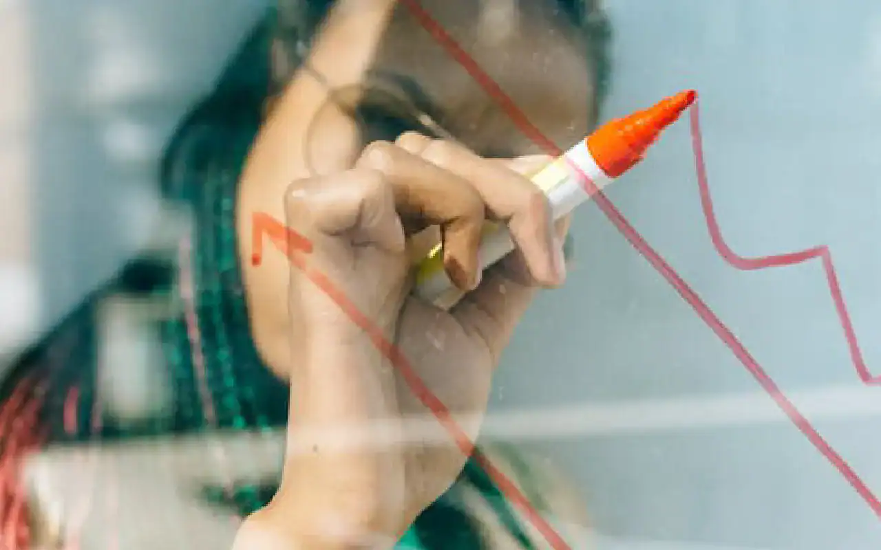 Woman writing on glass with marker, cybersecurity growth concept.