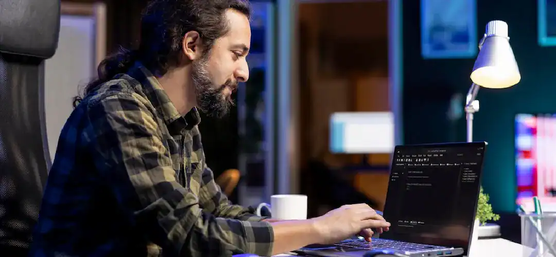 DevOps professional working on a laptop in a modern office setting.