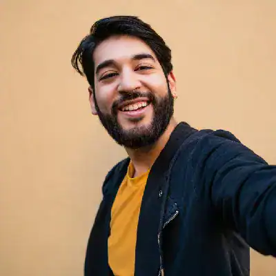 Smiling man taking a selfie, promoting Microsoft certification programs.