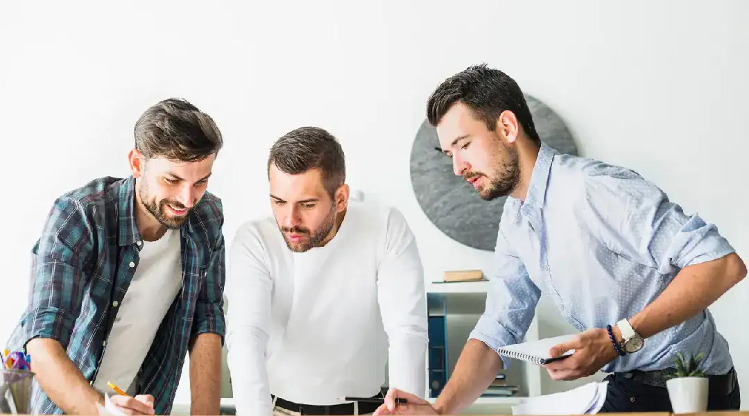 Group of three IT professionals collaborating on network certification training.