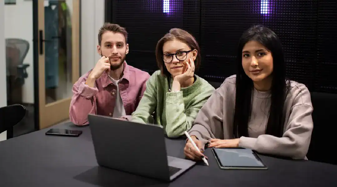 Diverse team collaborating on IT project in a modern office setting.
