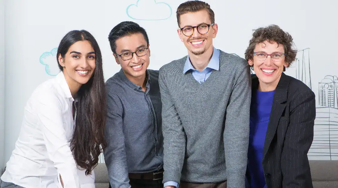 Group of diverse professionals smiling in an office setting.