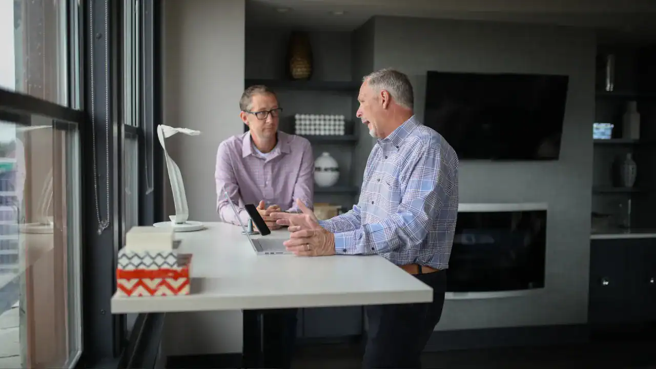 Business professionals discussing IT certifications at a modern office.