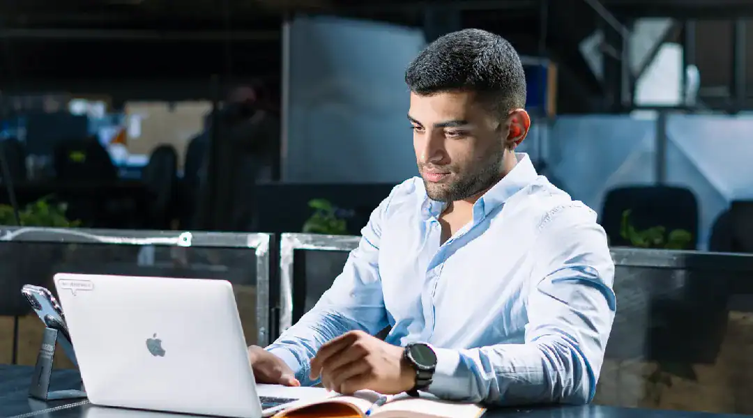 Young man studying Juniper JN0-104 networking certification at work.