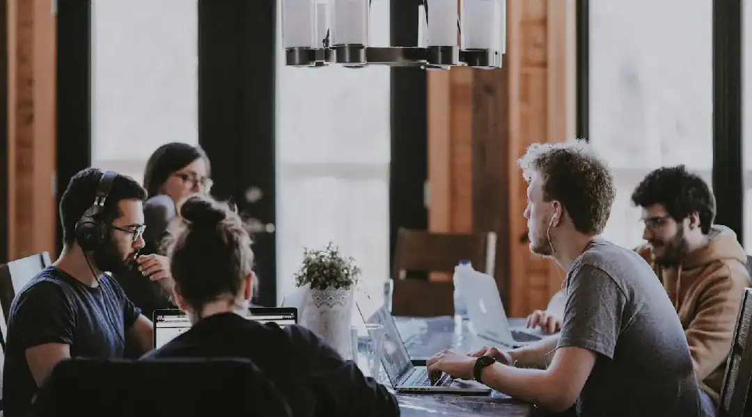 Team of data analysts working together on laptops in a bright, modern office.