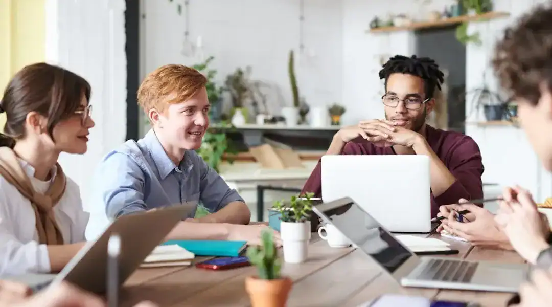 Group of young professionals discussing IT certifications in a modern office.