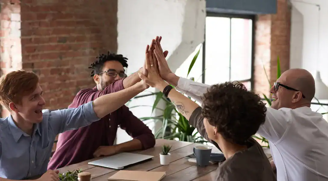 Group of professionals celebrating success in a modern office setting.