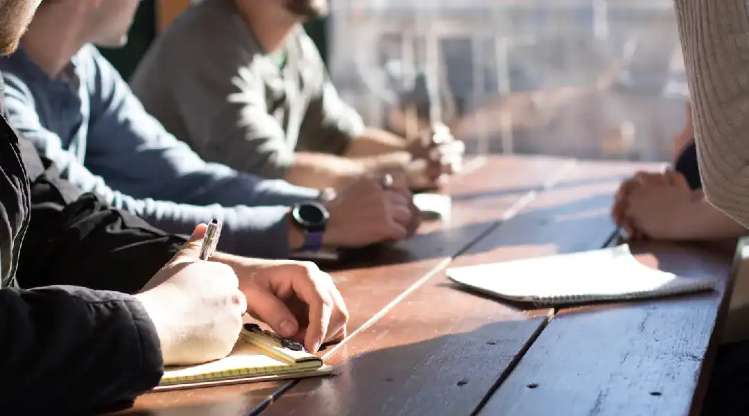 Group of professionals studying IT certifications at a conference table.