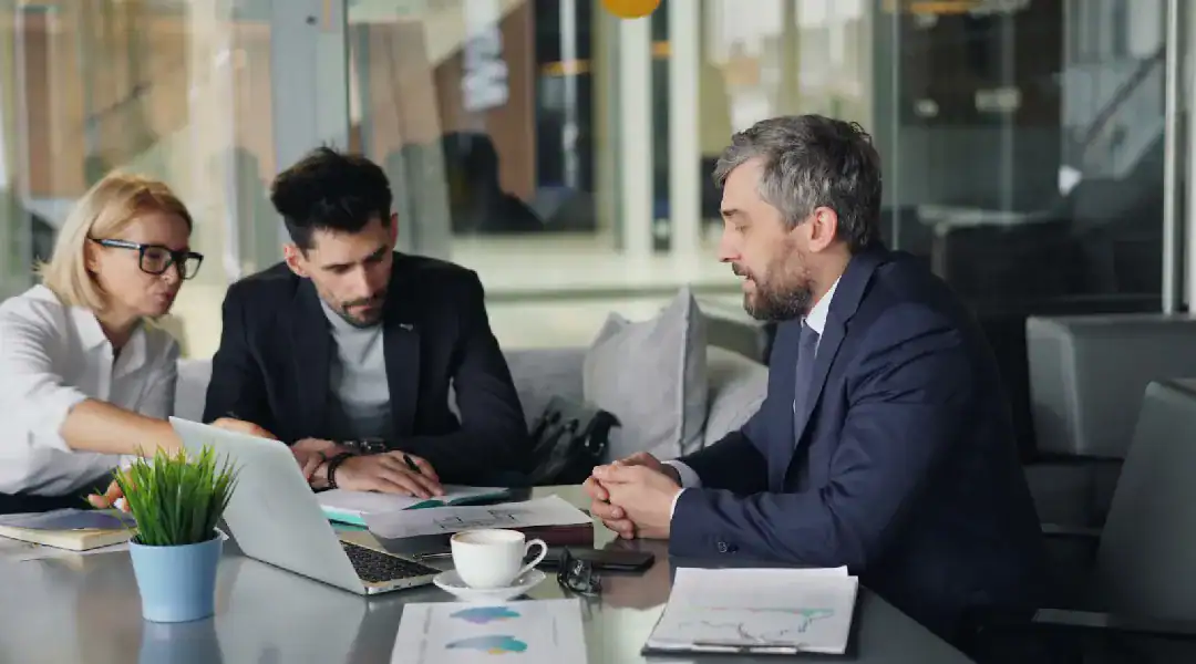 Business professionals discussing IT certifications in a modern office.
