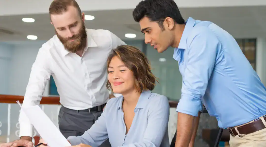IT professionals collaborating on certification materials in a modern office setting.