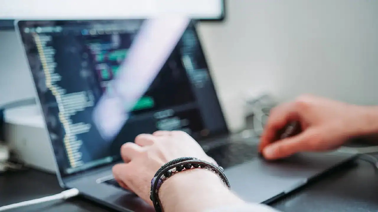 Person working on a laptop with Salesforce Service Cloud interface on screen.