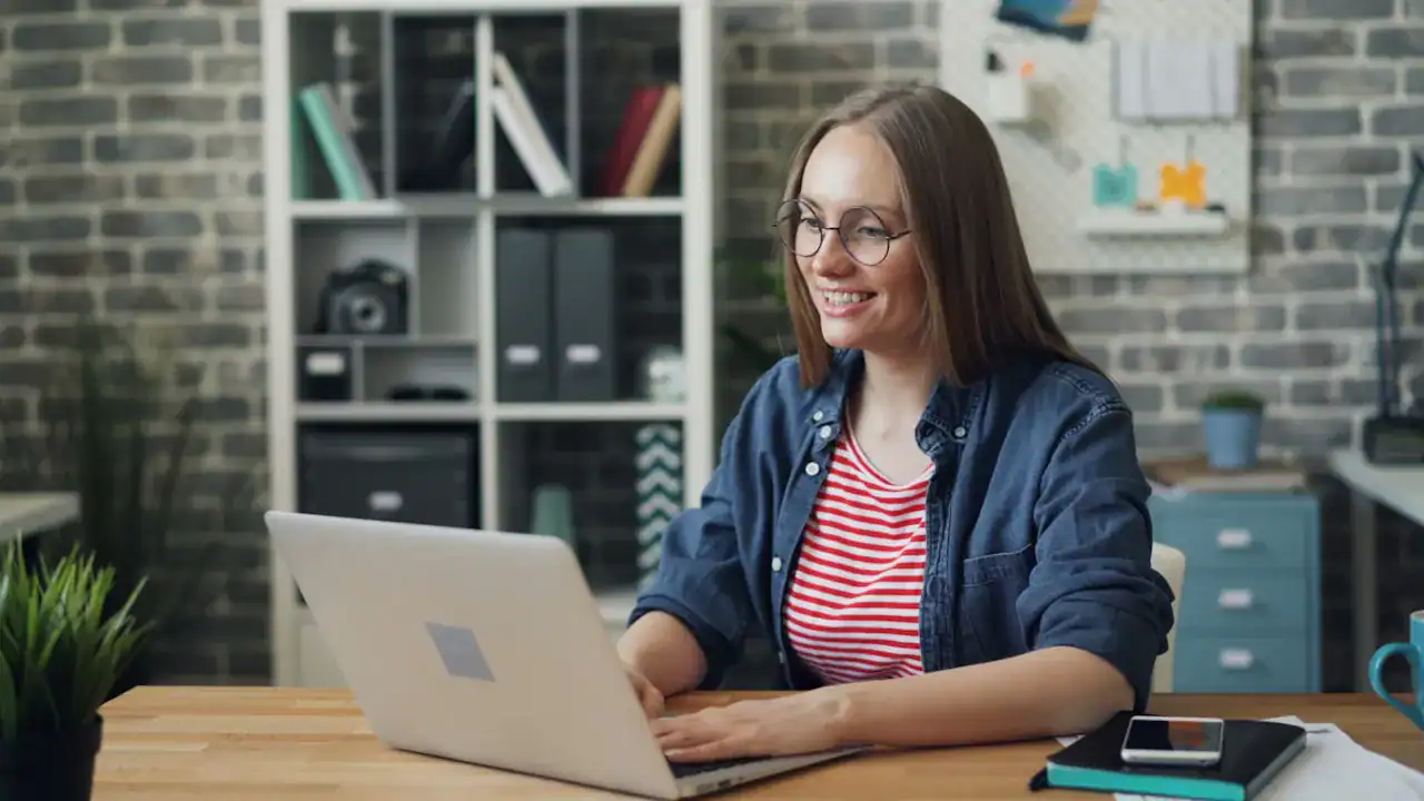 Woman working on a laptop to build and manage cloud networks securely.