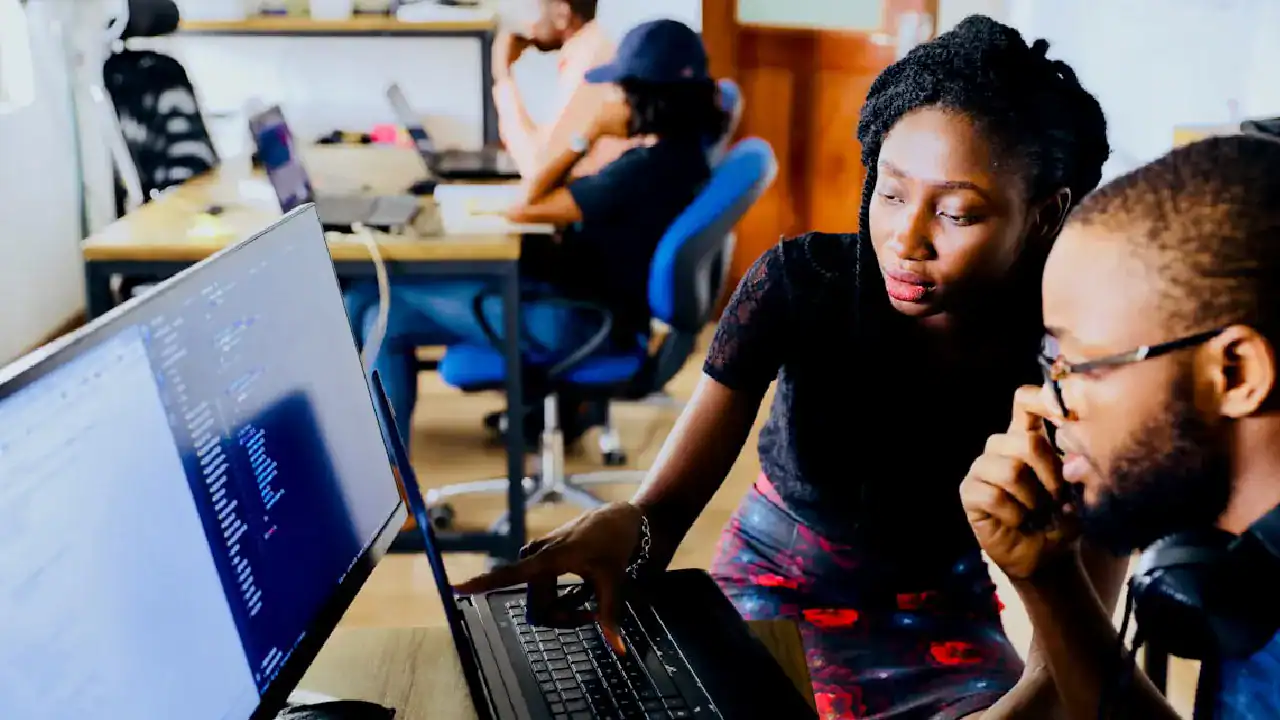 Students learning network security concepts on computers in a classroom.